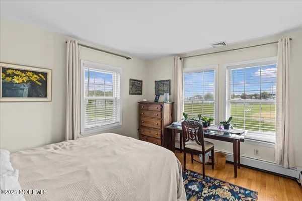 a bedroom with a bed and a table in it with wooden floor