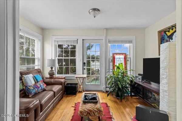 a living room with furniture a flat screen tv and a large window