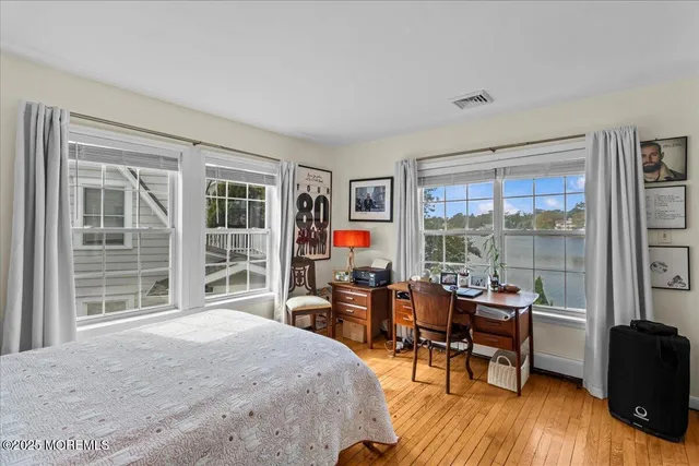 a bedroom with furniture and large windows