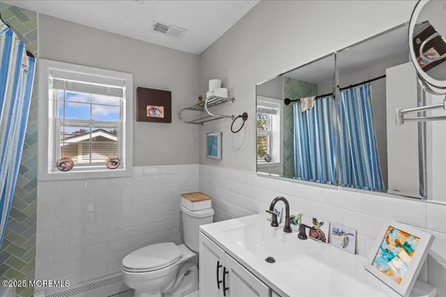 a bathroom with a sink a toilet and a mirror