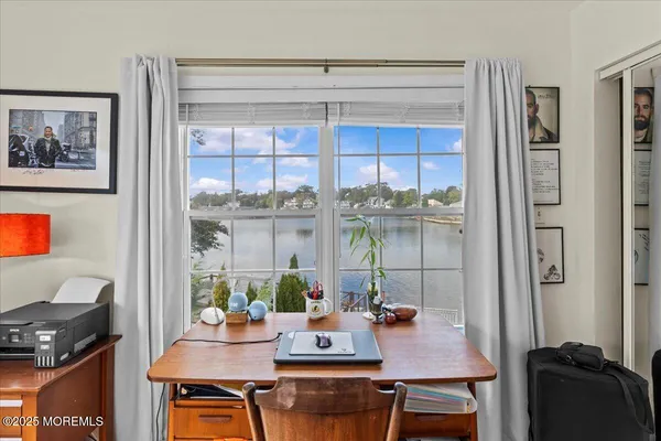 a view of a workspace with furniture and a window