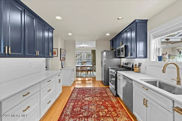 a large kitchen with stainless steel appliances granite countertop a sink dishwasher stove and refrigerator