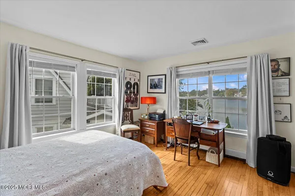 a bedroom with furniture and large windows