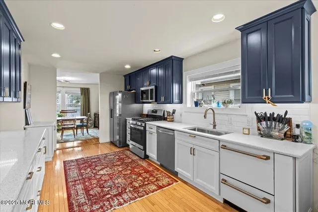 a kitchen with stainless steel appliances granite countertop a sink stove refrigerator and cabinets