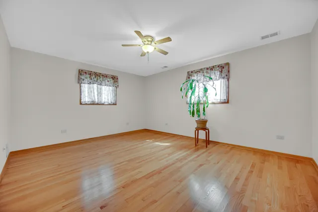 a view of empty room with window and wooden floor