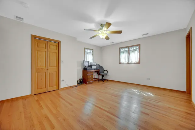 a view of a room with wooden floor and ceiling fan