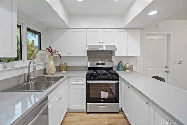 a kitchen with sink a stove and cabinets
