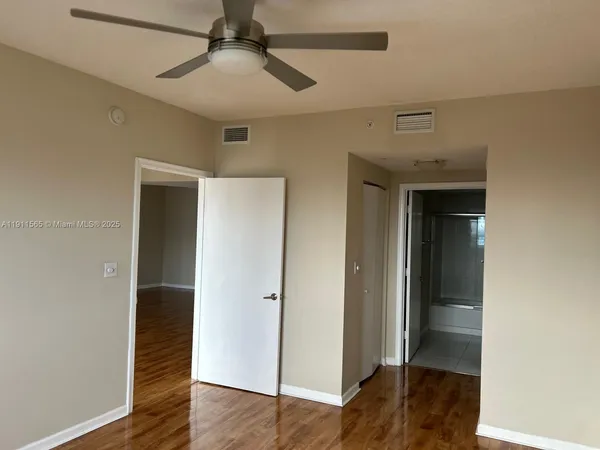 a view of empty room with wooden floor