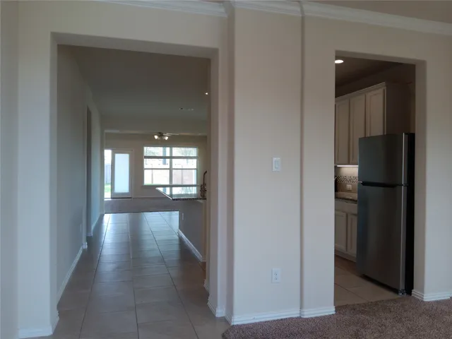 a view of hallway with windows and refrigerator