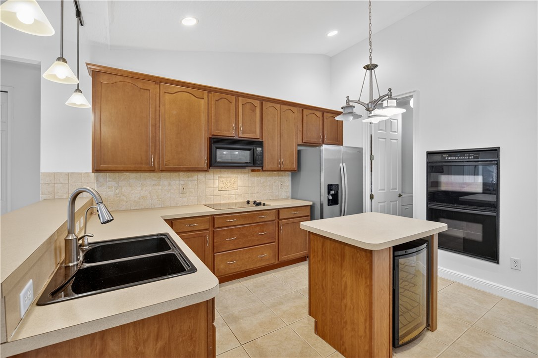 1712 Shakespeare Street Sebastian, FL 32958 - Photo 11 of 36 a kitchen that has a sink stainless steel appliances a refrigerator and a stove top oven