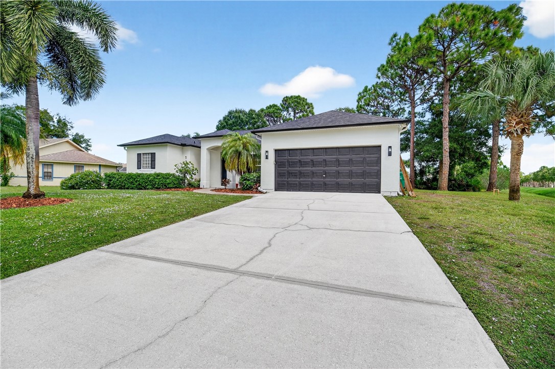 1712 Shakespeare Street Sebastian, FL 32958 - Photo 4 of 36 front view of a house with a yard and palm trees