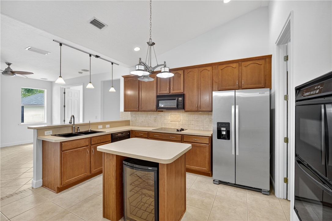 1712 Shakespeare Street Sebastian, FL 32958 - Photo 10 of 36 a kitchen with stainless steel appliances granite countertop a sink a stove a refrigerator and island