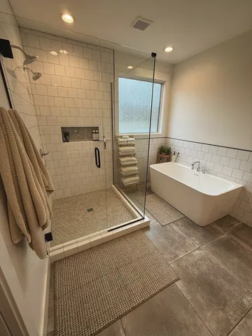 a bathroom with a tub sink and mirror
