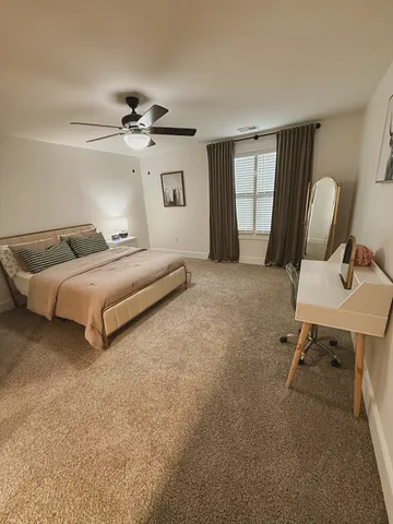 a spacious bedroom with a bed and chair