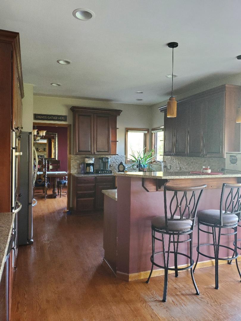 1385 Stonegate Road Algonquin, IL 60102 - Photo 15 of 32 a kitchen with a table chairs refrigerator and cabinets