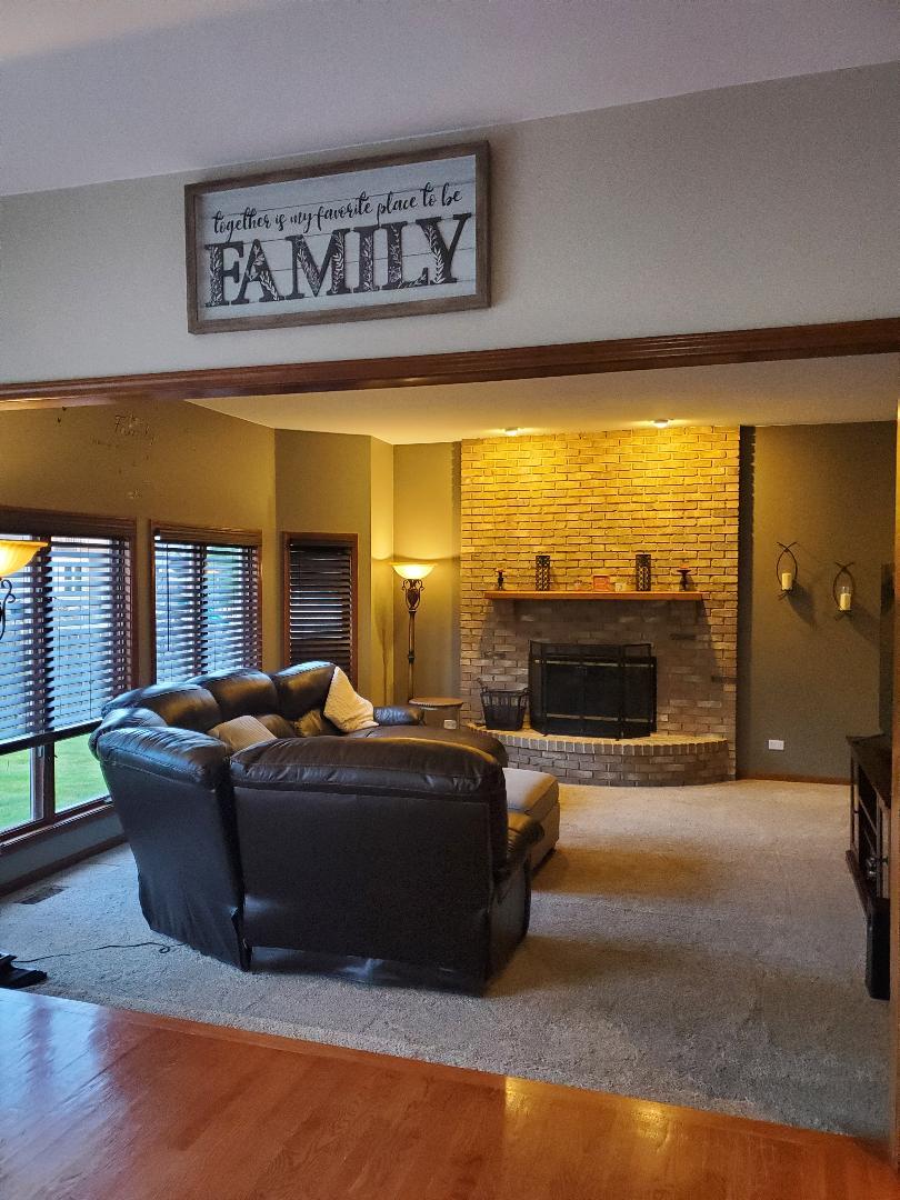 1385 Stonegate Road Algonquin, IL 60102 - Photo 16 of 32 a living room with furniture a fireplace and a flat screen tv