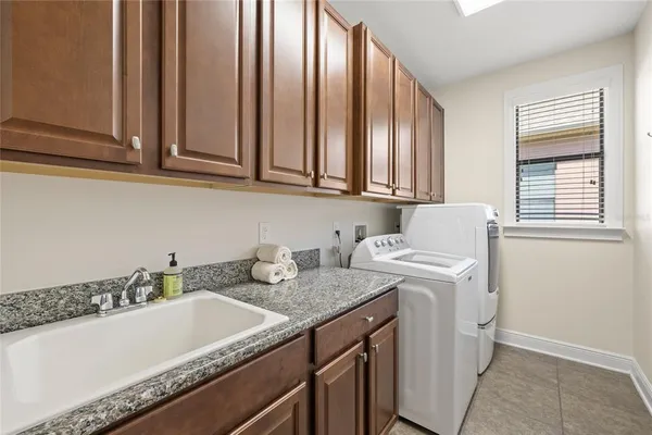 a bathroom with a granite countertop sink and a vanity next to a window