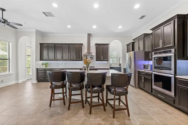 a kitchen with stainless steel appliances kitchen island granite countertop a refrigerator and microwave
