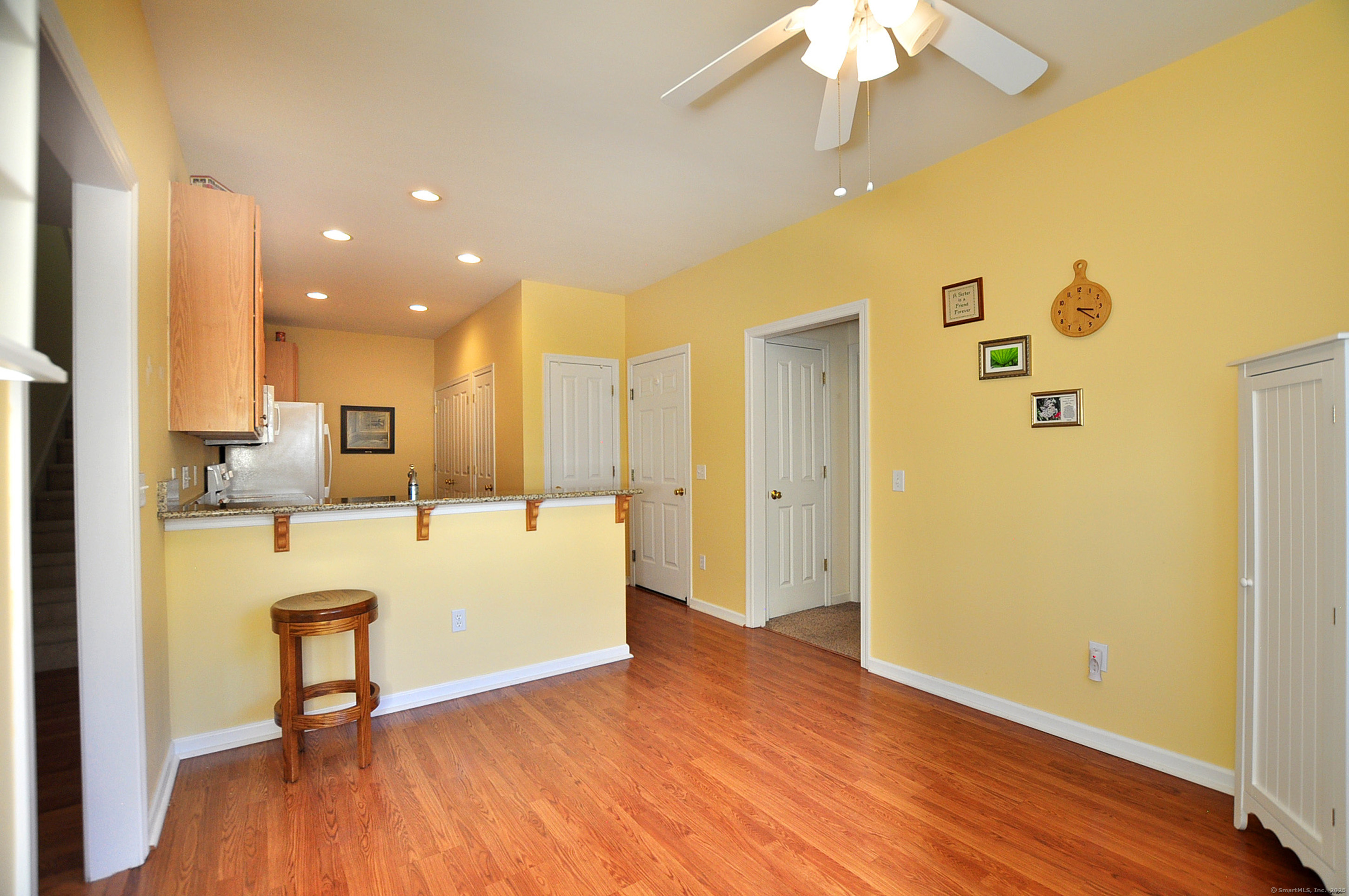 77 Carlson Ridge Road, Unit 77 New Milford, CT 06776 - Photo 13 of 40 a large living room with kitchen island stainless steel appliances furniture a refrigerator and a chandelier