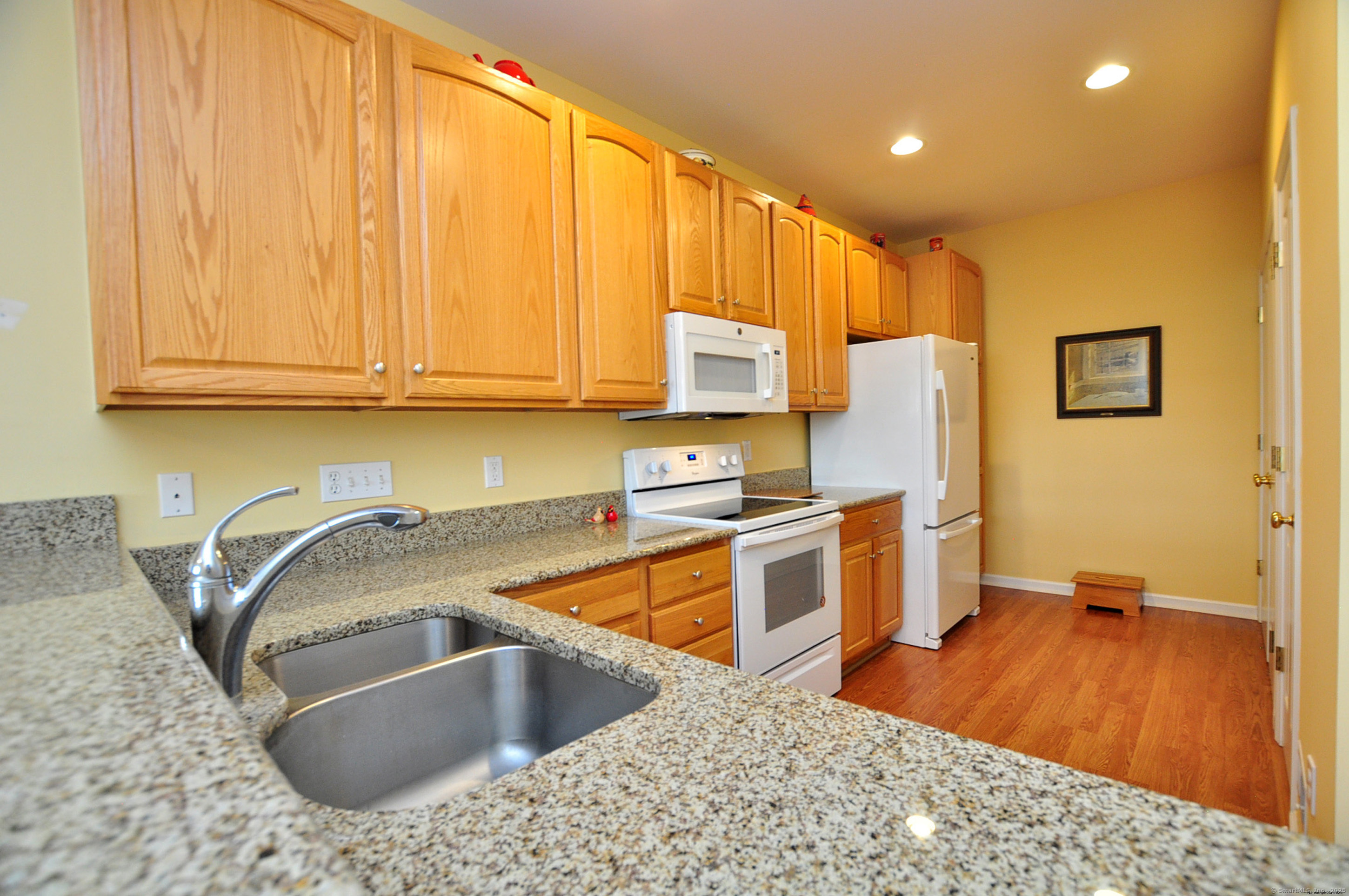 77 Carlson Ridge Road, Unit 77 New Milford, CT 06776 - Photo 15 of 40 a kitchen with stainless steel appliances granite countertop a sink a stove and a wooden cabinets