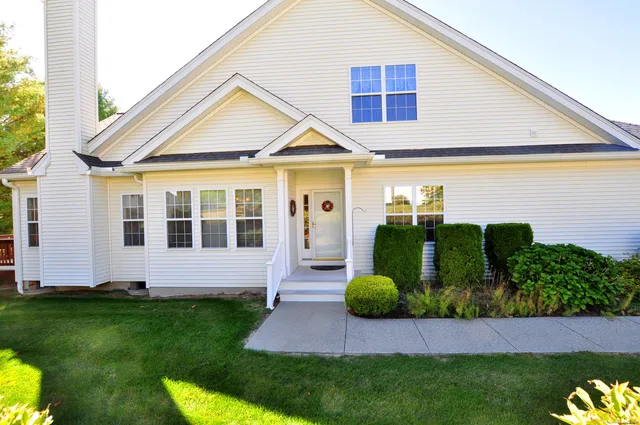 a front view of a house with a garden and plants