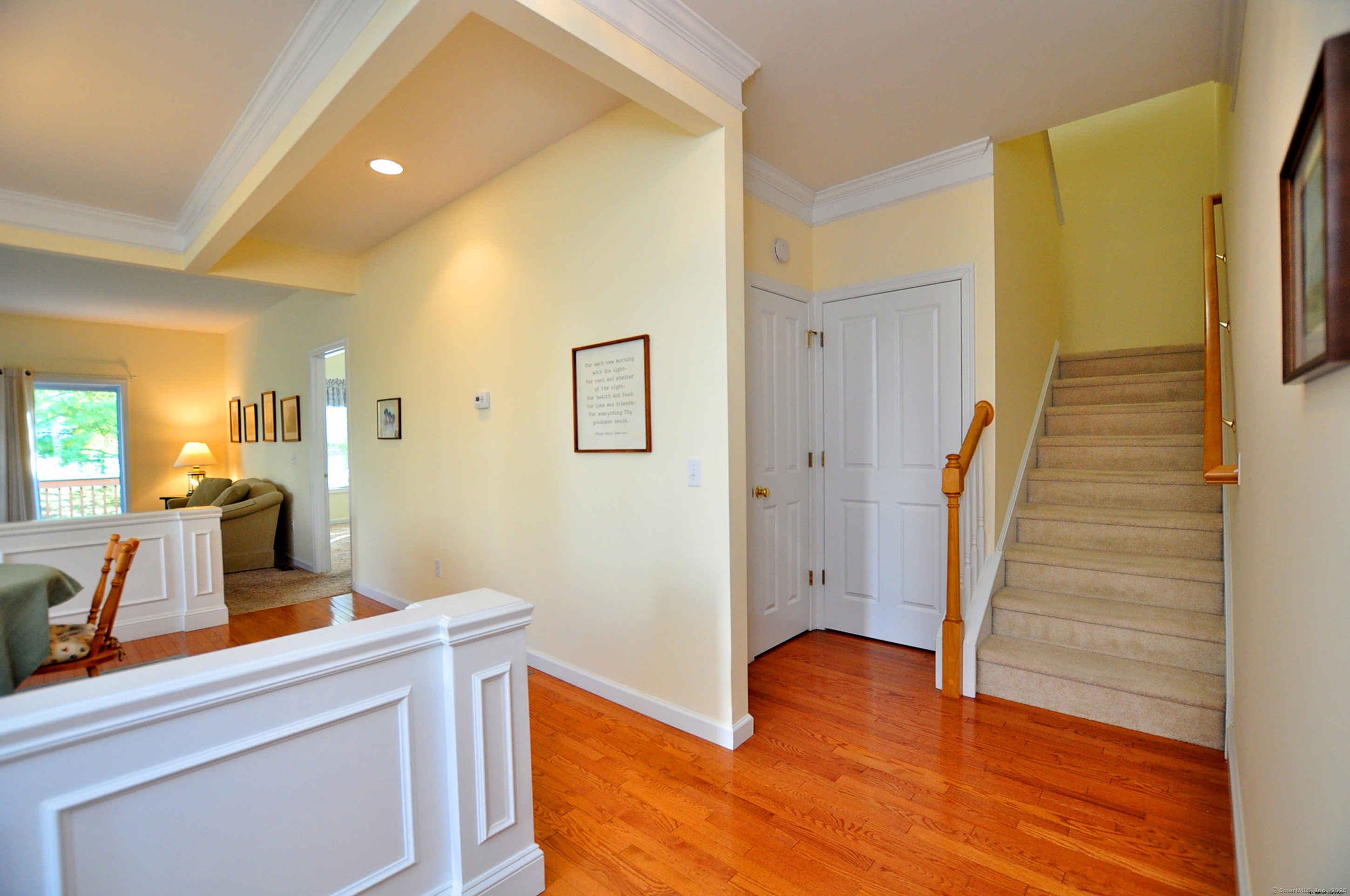 77 Carlson Ridge Road, Unit 77 New Milford, CT 06776 - Photo 6 of 40 a view of a hallway to a room with wooden floor and staircase