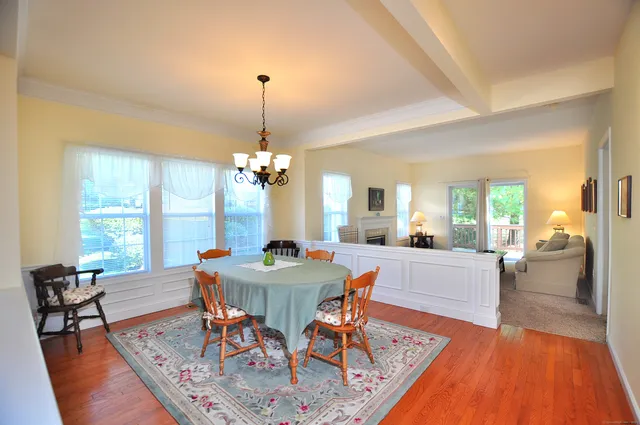 a view of a dining room with furniture a chandelier and wooden floor