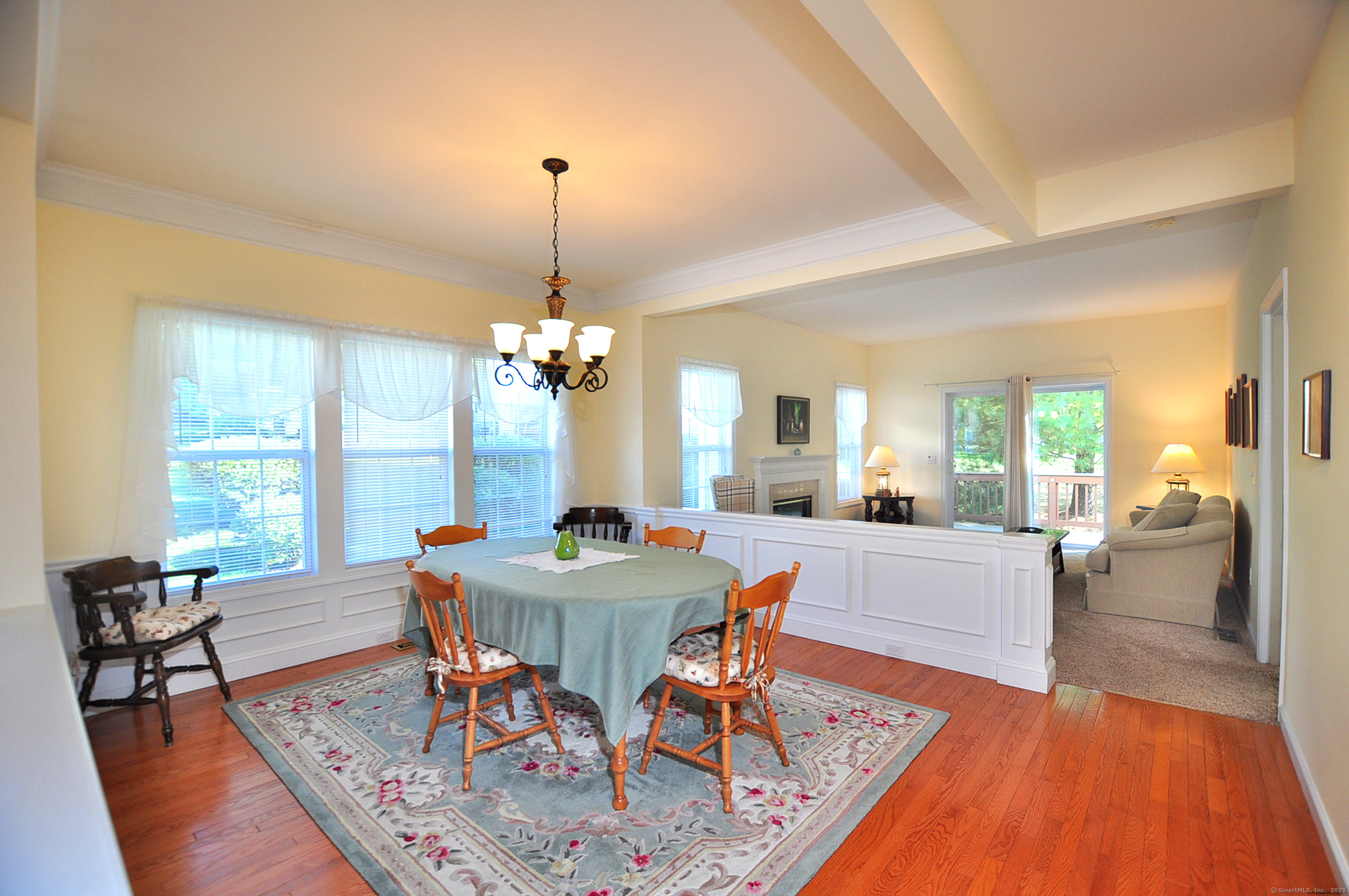 77 Carlson Ridge Road, Unit 77 New Milford, CT 06776 - Photo 8 of 40 a view of a dining room with furniture a chandelier and wooden floor