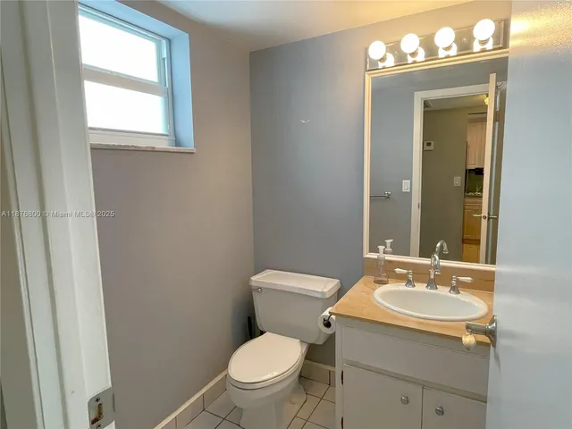 a bathroom with a toilet sink vanity and mirror