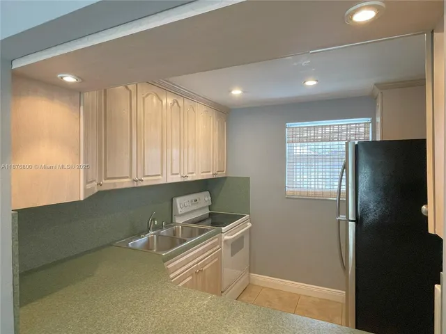 a kitchen with stainless steel appliances granite countertop a refrigerator and a sink