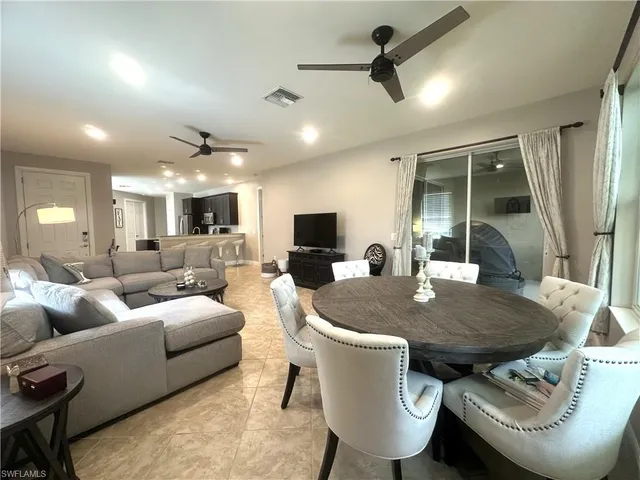 a living room with furniture a flat screen tv and a large window