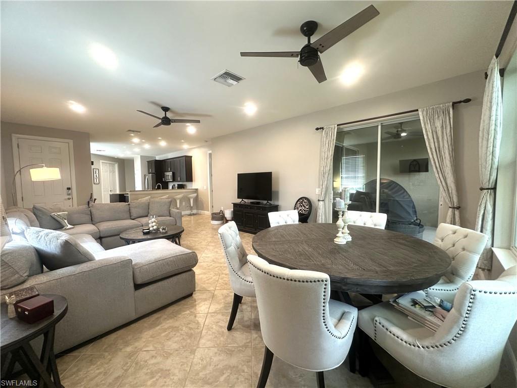 13462 Kent Street Naples, FL 34109 - Photo 11 of 30 a living room with furniture a flat screen tv and a large window