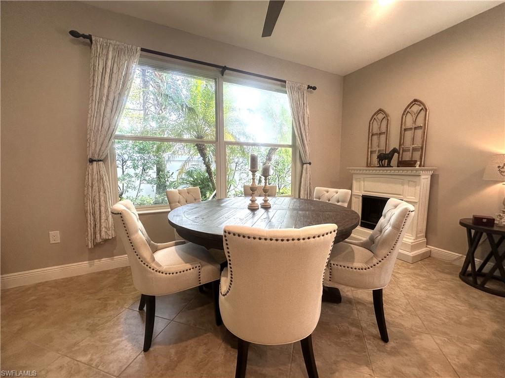 13462 Kent Street Naples, FL 34109 - Photo 13 of 30 a dining room with furniture a fireplace and wooden floor