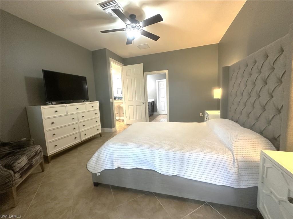 13462 Kent Street Naples, FL 34109 - Photo 15 of 30 a bedroom with a bed and a flat tv screen on dresser