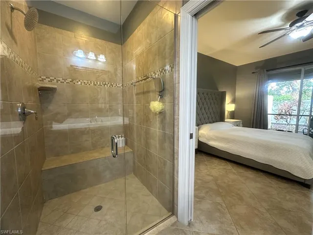 a bathroom with a granite countertop shower a sink and a mirror