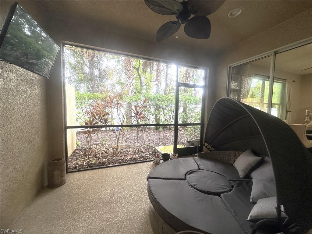 13462 Kent Street Naples, FL 34109 - Photo 22 of 30 a living room with furniture and a floor to ceiling window