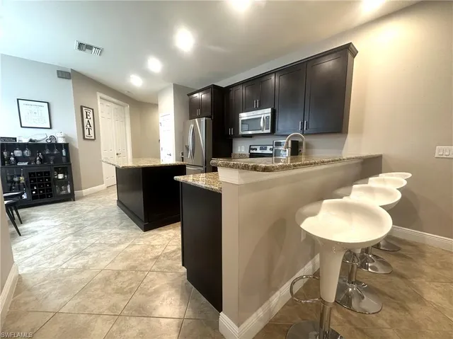 a kitchen with kitchen island a cabinets a counter top space appliances and a sink