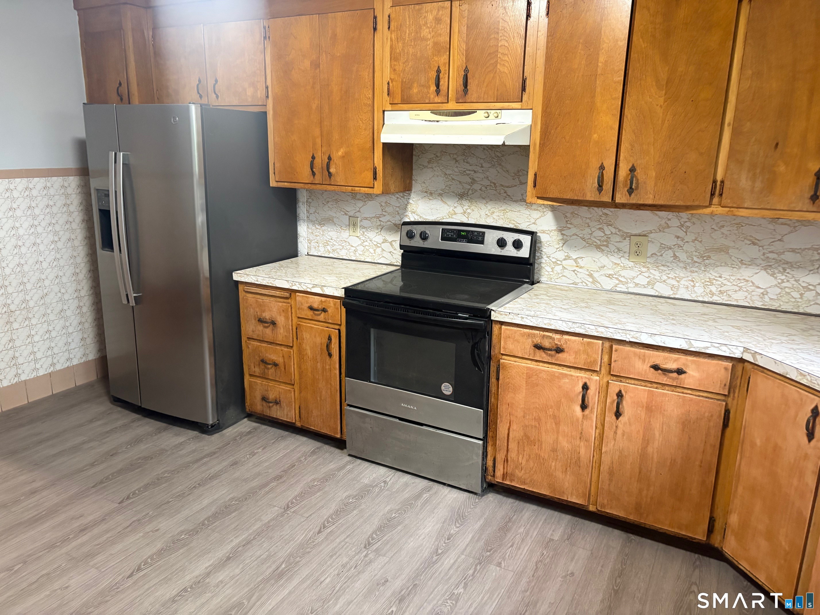580 High Street Middletown, CT 06457 - Photo 3 of 11 a kitchen with granite countertop wooden cabinets and a stainless steel refrigerator