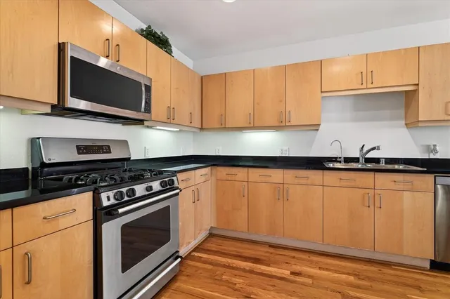 a kitchen with stainless steel appliances wooden cabinets and a stove top oven
