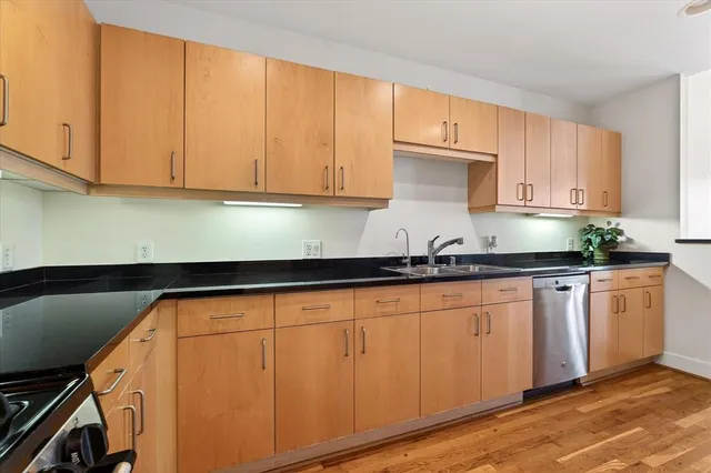 a kitchen with granite countertop white cabinets and stainless steel appliances
