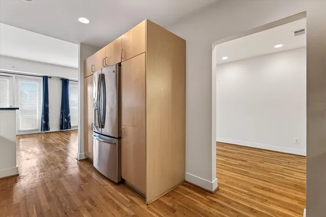 a kitchen with stainless steel appliances a refrigerator and wooden floor