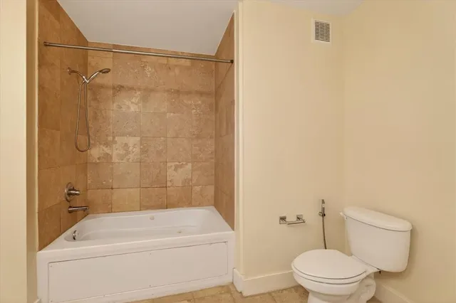 a bathroom with a shower a toilet and a sink