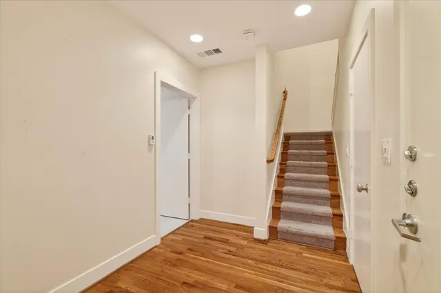 a view of a hallway with wooden floor and entryway