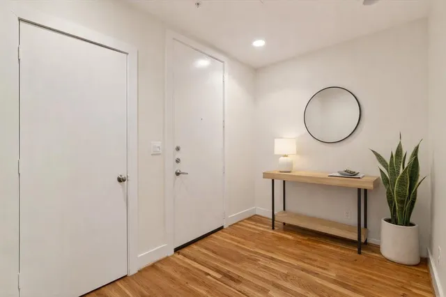 a view of a room with wooden floor and a potted plant