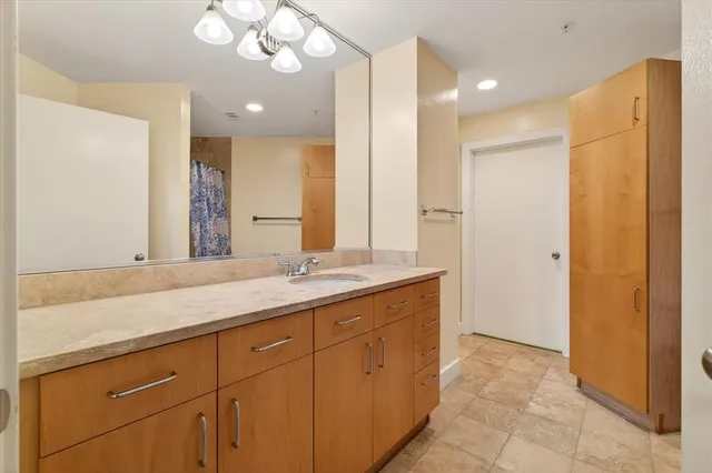 a bathroom with a granite countertop sink a large mirror and a shower