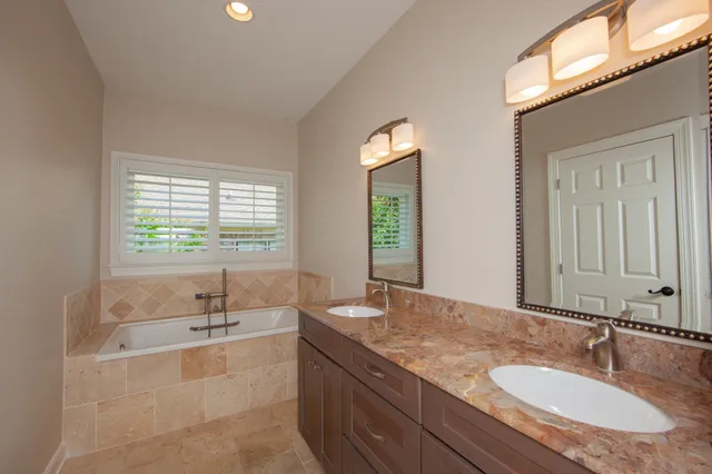 a bathroom with a granite countertop sink and a large mirror