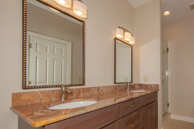 a bathroom with a granite countertop sink and a mirror
