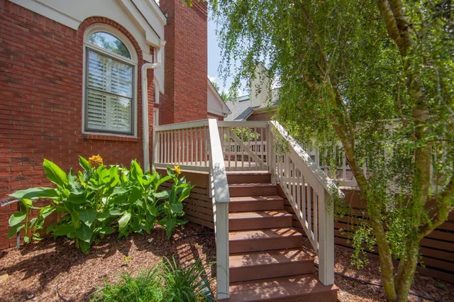 a view of a brick house with a large tree