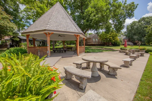 a view of backyard with table and chairs under an umbrella