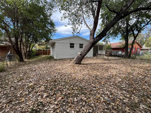 a white house that has a tree in front of it
